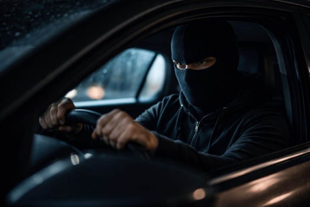 Car thief driving away in balaclava