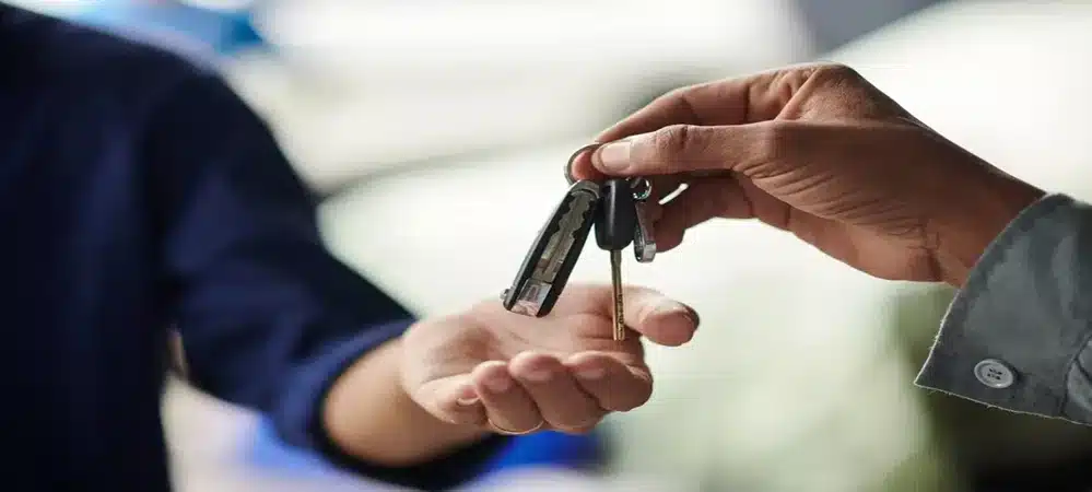 Handing over spare car keys and remote fobs to a driver, provided by Northside Car Keys for fast auto replacement.