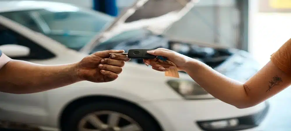 Customer handing over a car key remote to a mechanic at Northside Car Keys